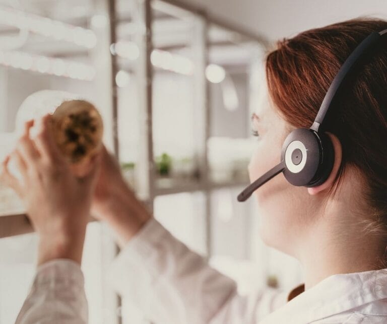 Työntekijä kasvilaboratoriossa tutkimassa taiminäytettä. Päässä Nopteraa käyttävä headset.